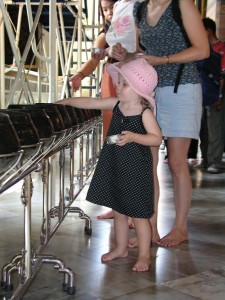 Emmy & Brenda dropping coins in Monk's bowls for luck-Wat Pho